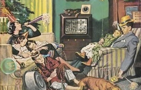 A family sitting on a couch watching TV in 2021.