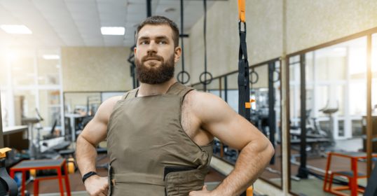 A bearded man in a gym posing for a photo.