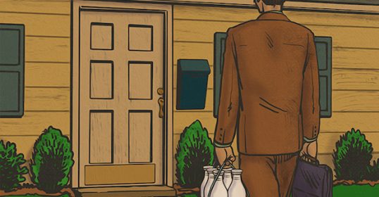 A man in a cream suit walking down the street.