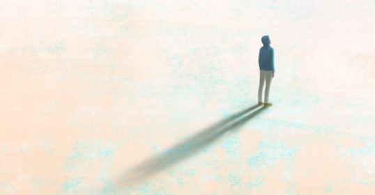 A shadow of a man standing on the ground, reflecting his dreams.