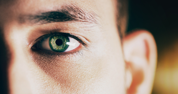 A close up of a man's eye with envy-inducing green eyes.