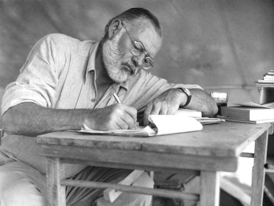 A man at a table writing a book, inspired by Ernest Hemingway.