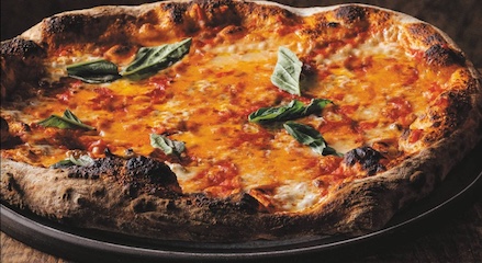 A perfect pizza with tomato sauce and basil on a plate.