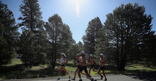 A group of people running on a road with trees in the background, showing their pro skills.