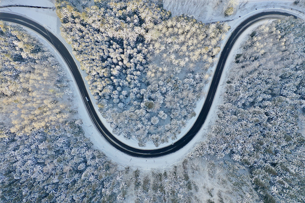 An aerial view of a U-shaped curve road in the snow.