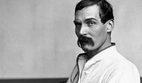 A black and white photo of a man with a mustache.