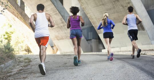 A group of people engaging in physical activity under a bridge.