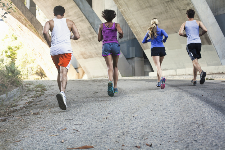 A group of people engaging in physical activity under a bridge.