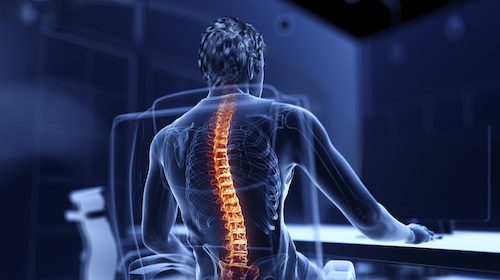 A man with good posture sits at a desk, facing the future.