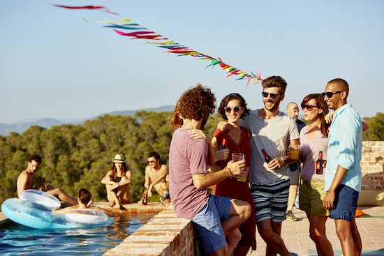 A group of people standing around a pool.