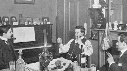 Three men sitting at a table with a bottle of wine, possibly celebrating an ideal bachelor party in 1906.