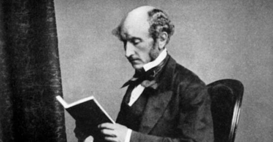 A man reading a book in a chair.