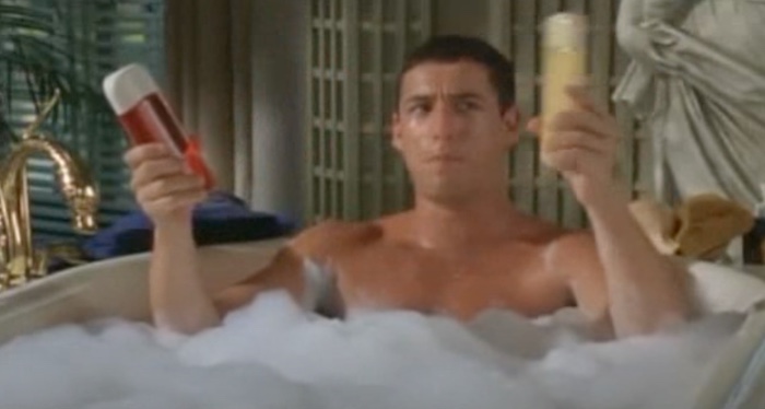 A dude sitting in a bathtub with shampoo.