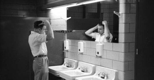 A man standing in front of two sinks in a bathroom, Keywords.