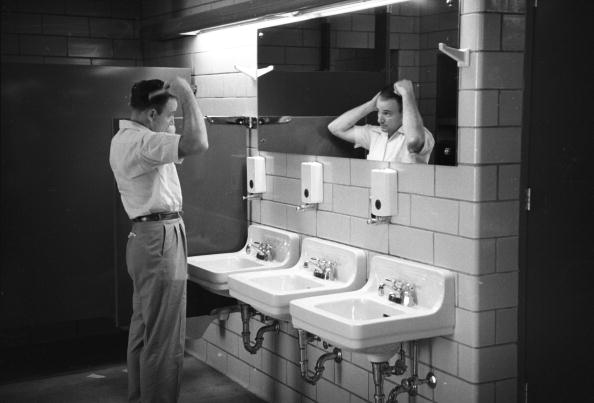 A man standing in front of two sinks in a bathroom, Keywords.