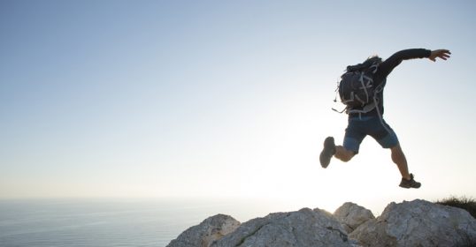 A man jumping off a cliff, showcasing his physical identity.