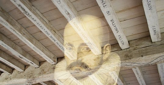 An image of a man with a beard under a wooden ceiling, reflecting on life and the words of Michel de Montaigne.