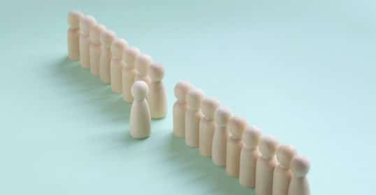 A line of well-differentiated wooden figures, becoming a leader.