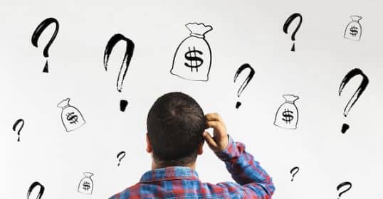 A man glancing at a wall covered in drawn money bags, exploring personal finance.