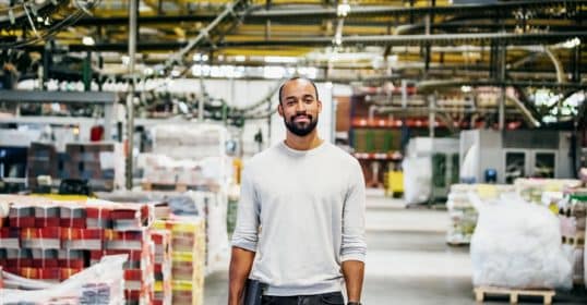 A black man standing in a warehouse.