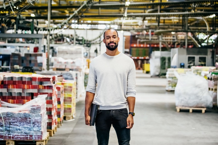 A black man standing in a warehouse.