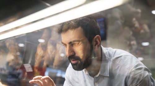 A man with self-control examines bread in a bakery.