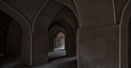 The interior of the mosque features arches and pillars.