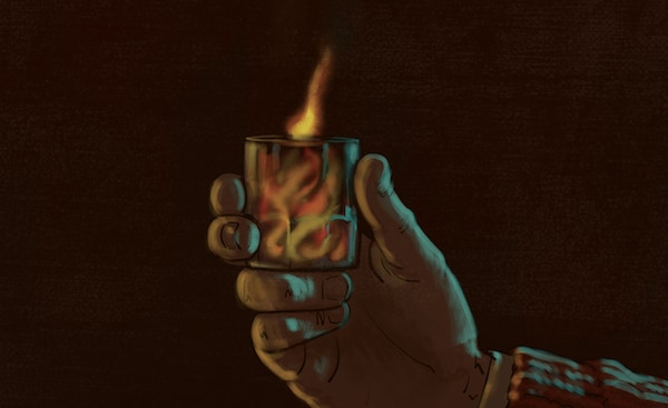 A hand holding a glass with Sunday Firesides flames inside it against a dark background.