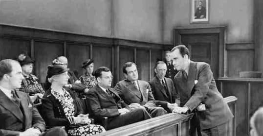 A black-and-white image of a courtroom scene titled