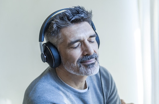Man enjoying a podcast on "Why You Like Music" with headphones.