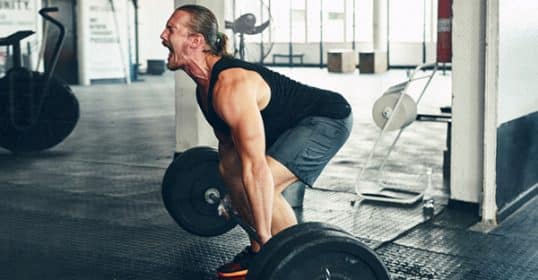 Man yelling while performing a deadlift at the gym.