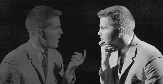 Two identical men engage in a Sunday Firesides conversation on personal development, with one gesturing toward the other.