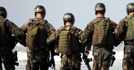 Soldiers in combat gear observing the coastline discuss leadership on Podcast #923.