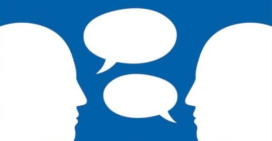 Two silhouetted profiles facing each other with speech bubbles indicating a conversation on the