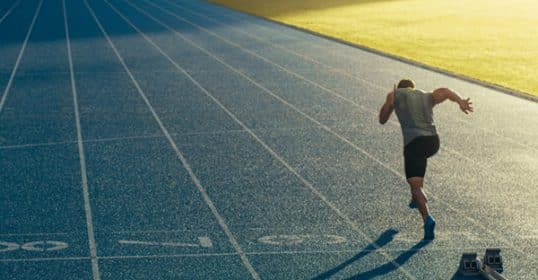 A grown-up's guide to an athlete sprinting on a track field from the starting blocks.