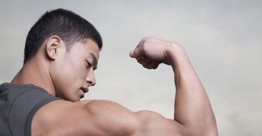 Young man flexing his bicep to showcase the science of swole.