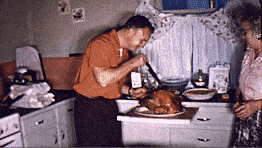 A man carving a turkey in a vintage kitchen as a woman looks on, capturing the essence of Thanksgiving.