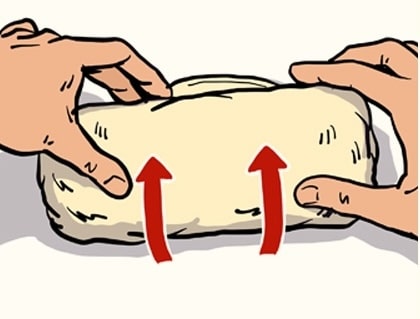 Two hands shaping dough with upward arrows indicating how to fold a burrito.