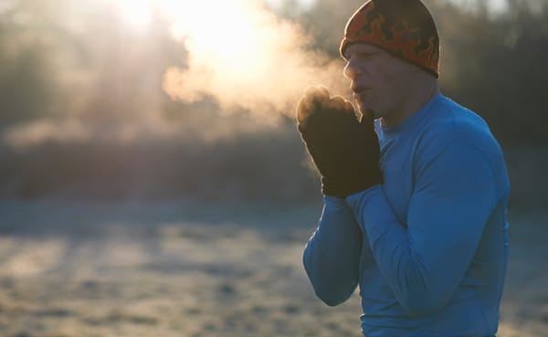 A spirit wearing a beanie and hat with breath coming out of his mouth.