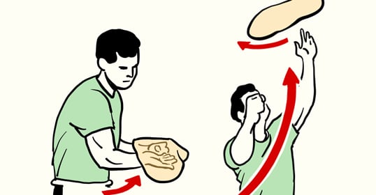 A man is tossing a frisbee to another man in the air.