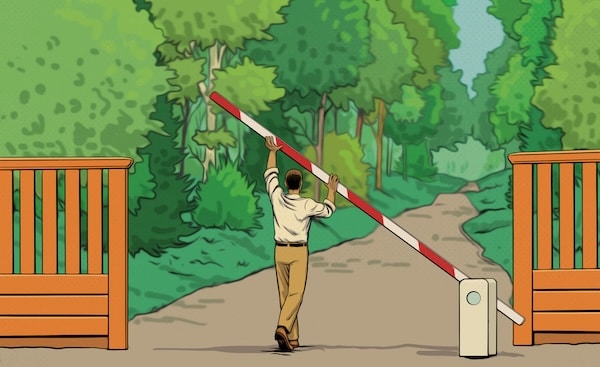 A person in a white shirt and beige pants raises a red and white barrier gate to open access to a forested park path on a quiet Sunday Firesides.