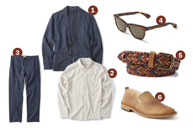 A navy blazer, white button-up shirt, navy trousers, tortoiseshell sunglasses, multicolored braided belt, and tan slip-on shoes are arranged on a white background—a perfect Summer Smart Casual option for warm weather outings.