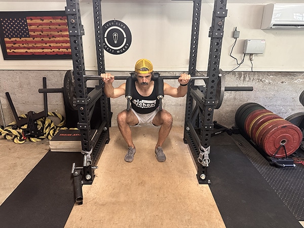 a man squatting in a gym