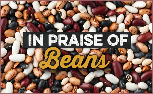 Close-up of various legumes with the text "In Praise of Beans" overlaying the image, celebrating their versatile use in every delicious big pot recipe.