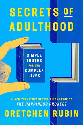 Book cover for "Secrets of Adulthood" by Gretchen Rubin, featuring bold, capitalized text and a hand holding a small book against a blue and yellow background—perfect for fans of Life Lessons from the Adulthood Podcast.