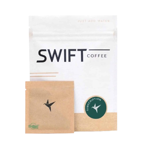 A white SWIFT Coffee package with black text, a small brown Instant Coffee packet featuring a hummingbird logo, and a green sticker labeled "Subscription," all set against a neutral background.
